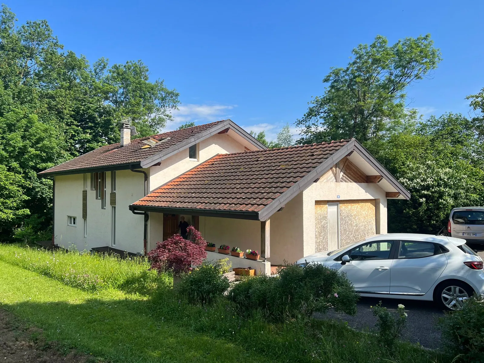 Maison avec plusieurs pans de toiture en tuiles.
